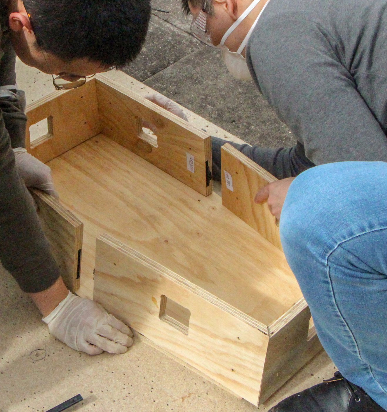 A plywood HexBox module being assembled by hand.